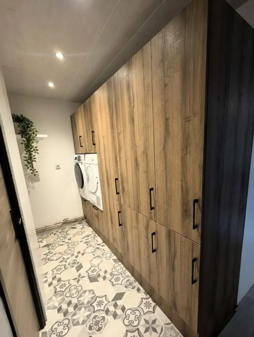 Buanderie en bois foncé avec grands rangements toute hauteur