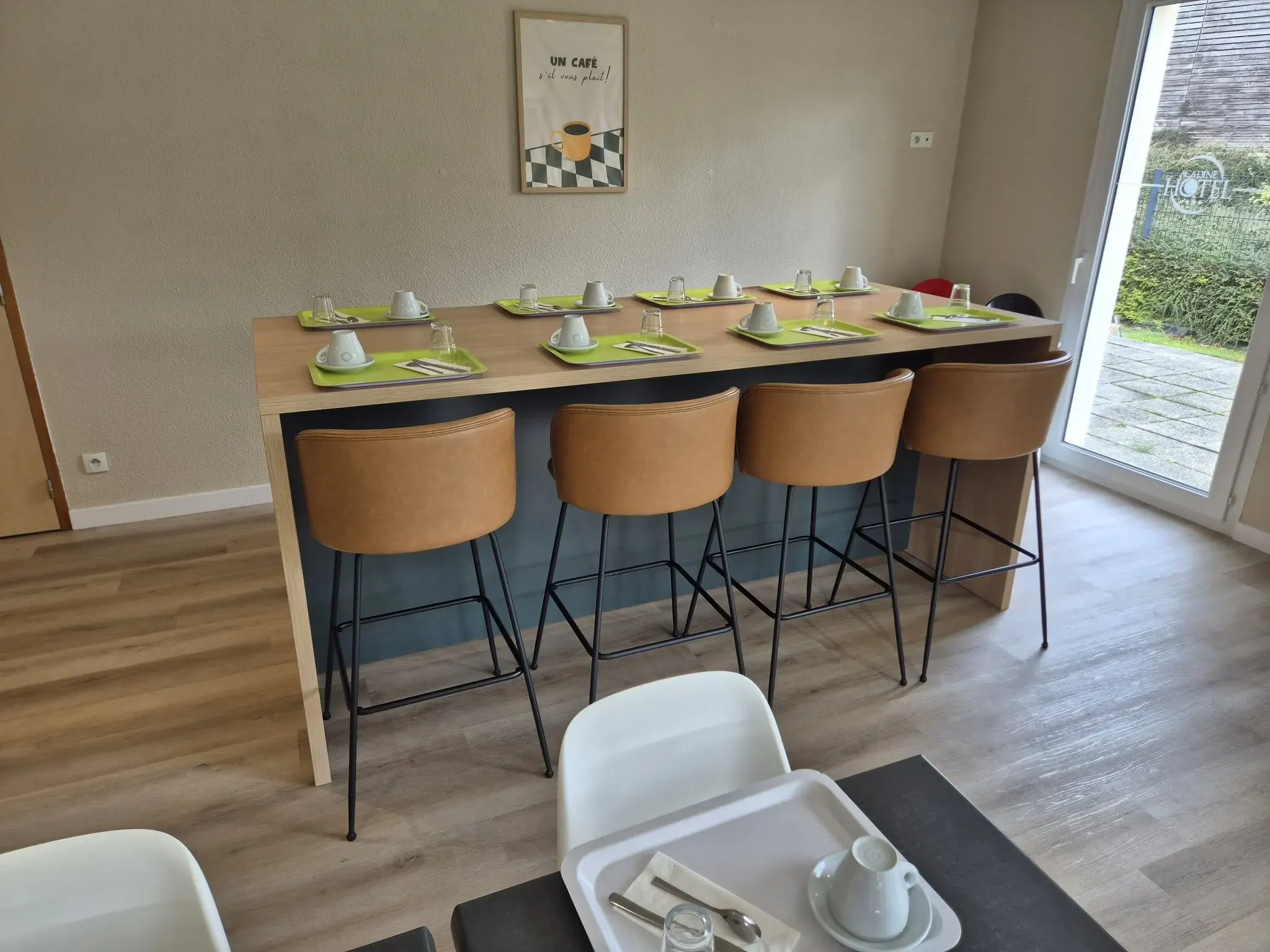 Espace repas et petit-déjeuner avec grande table haute et tabourets